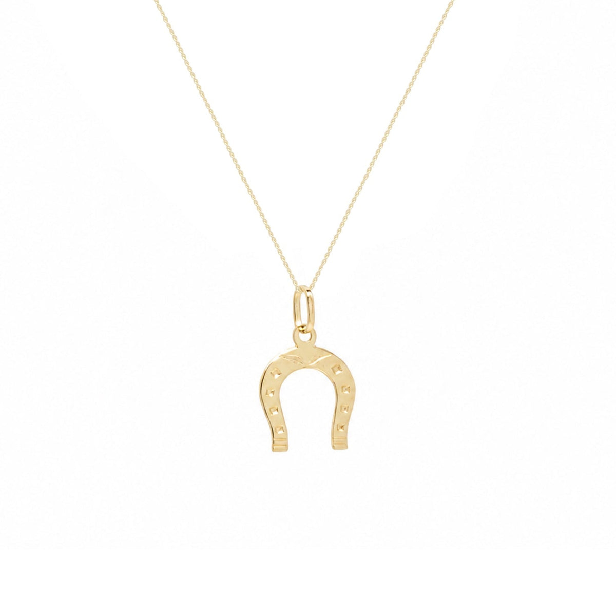 A delicate gold chain necklace featuring a small horseshoe pendant with tiny engraved stars, displayed against a solid white background.