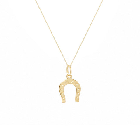A delicate gold chain necklace featuring a small horseshoe pendant with tiny engraved stars, displayed against a solid white background.
